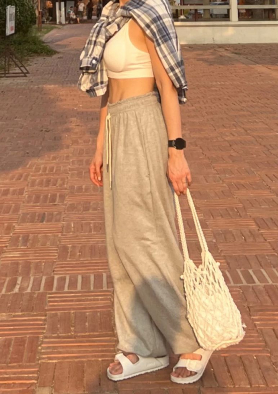 UnniAoPoNX in a sleeveless dress after tummy tuck showing natural waist contour.
