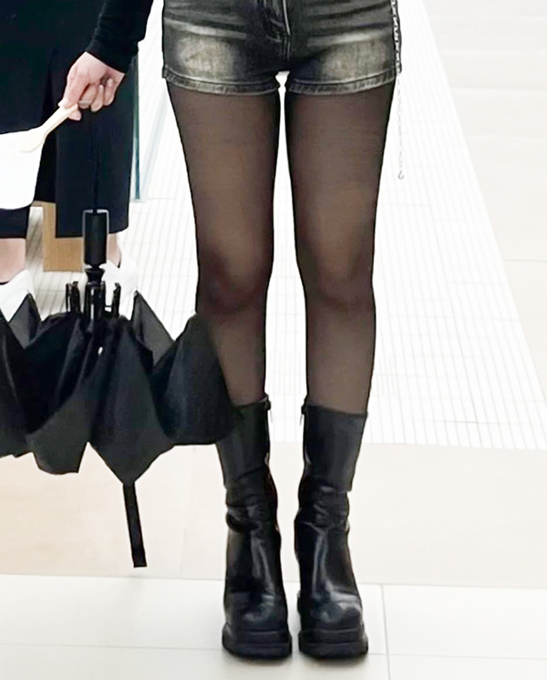 Thighs appear slimmer and more defined in sheer black tights post-surgery.